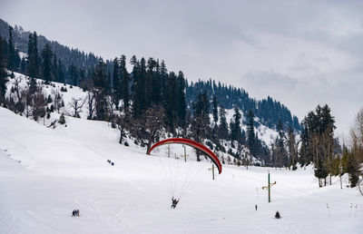 Woman paragliding against snowcapped mountain