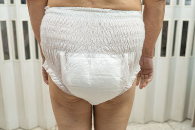 Rear view of woman standing against white wall