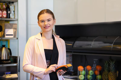 Portrait of smiling young woman standing in store