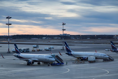 Airplane on airport runway against sky