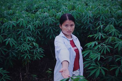 Portrait of girl standing against plants