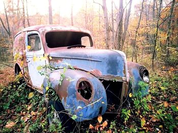 Old abandoned car on field