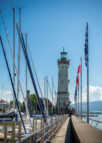 Lighthouse at harbor against sky