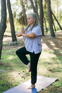 Portrait of young woman exercising on field