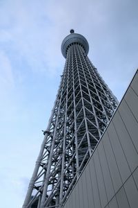 Low angle view of skyscraper against cloudy sky