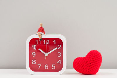 Close-up of red heart shape on wall against white background