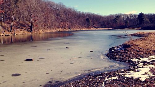 Scenic view of lake against sky during winter