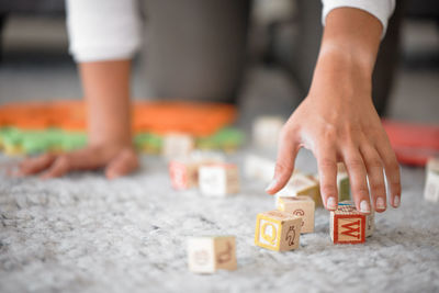 Low section of man playing with toy blocks