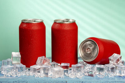 Red soda can on blue background and with ice and cold