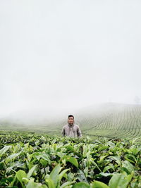 Man standing on field against sky