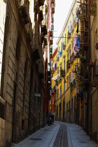 Alley amidst street in city against sky