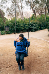 Full length of boy on swing in playground