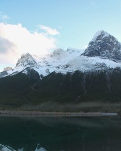 Scenic view of lake by mountains against sky