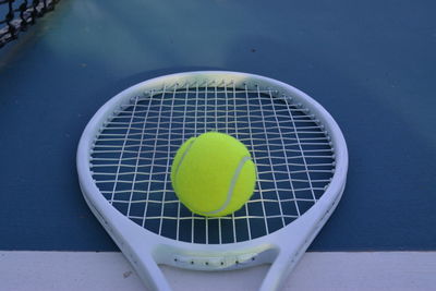 High angle view of ball on tennis racket at sports court