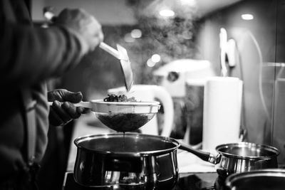 Midsection of man preparing food in kitchen