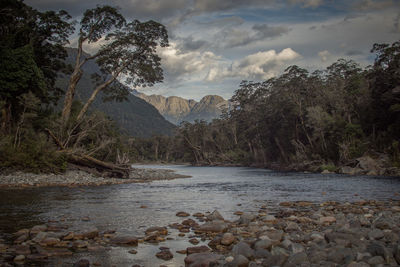 Scenic view of river and mountains against sky