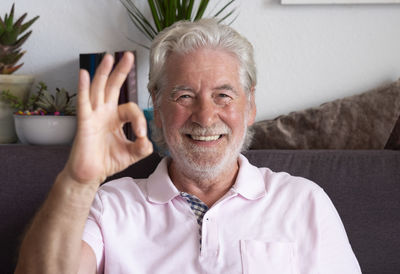 Portrait of smiling man gesturing at home
