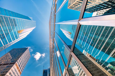 Low angle view of modern buildings against blue sky