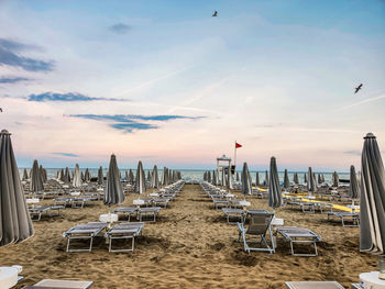 Chairs on beach against sky