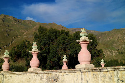 Statue amidst plants and buildings against sky