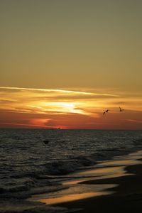 Scenic view of sea against orange sky