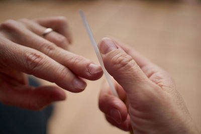 From above crop person cutting nails with clipper while doing manicure person