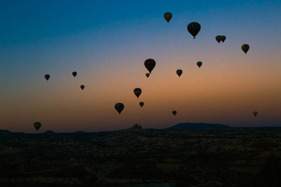 Hot air balloons flying over cappadocia during sunset