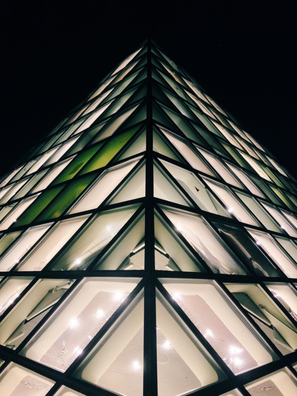 low angle view, architecture, built structure, modern, building exterior, glass - material, office building, tall - high, skyscraper, tower, city, pattern, sky, illuminated, architectural feature, building, night, clear sky, window, no people