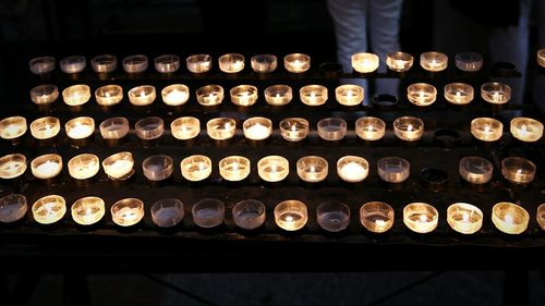 High angle view of burning tea light candles at cologne cathedral