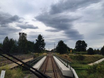 Railroad track against cloudy sky