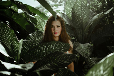 Portrait of young woman amidst leaves