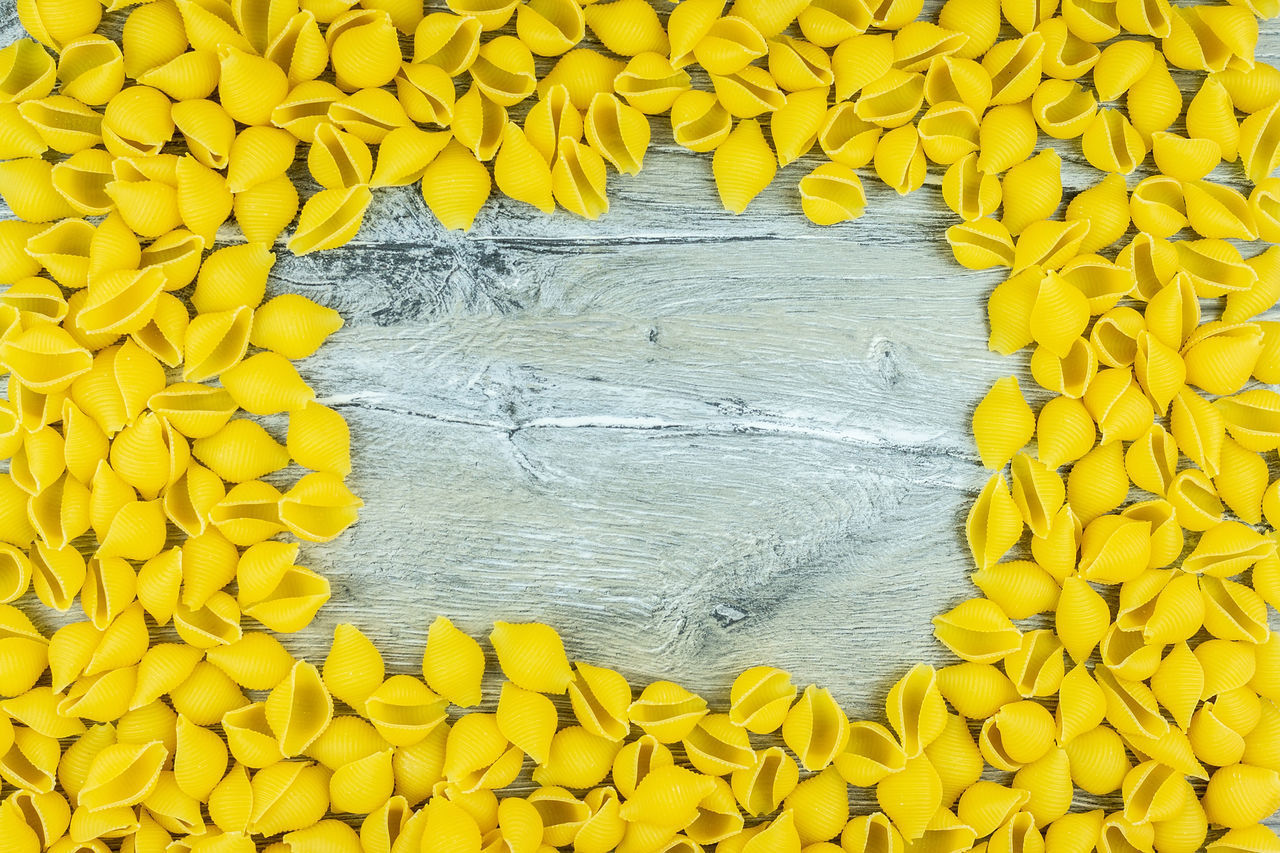 HIGH ANGLE VIEW OF YELLOW FLOWERING PLANT ON WOOD