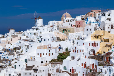 Buildings in town against blue sky