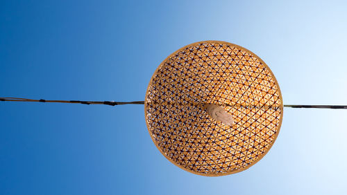 Low angle view of lighting equipment hanging against clear blue sky