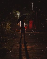 Full length of woman walking on illuminated city at night