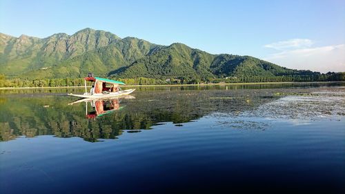 Scenic view of lake by mountain against sky