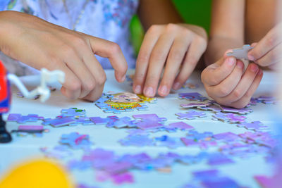 Cropped image of children playing with puzzle