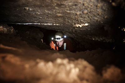 High angle view of spelunker standing in cave