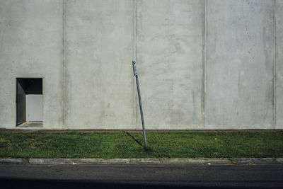 Gardening equipment on grassy field against wall