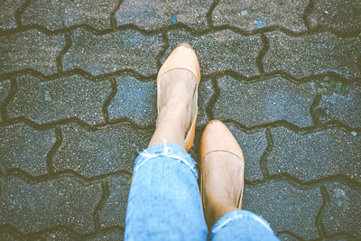 Low section of woman standing on footpath