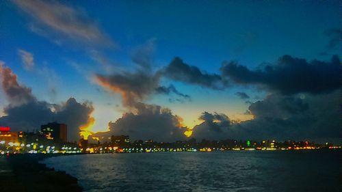 Illuminated cityscape against sky at night