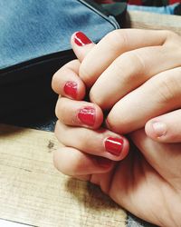 Midsection of woman hand with red tattoo