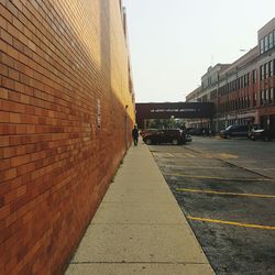 Sidewalk in city against clear sky