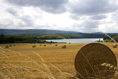 Hay bales on field against sky