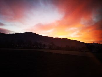 Scenic view of silhouette mountains against dramatic sky