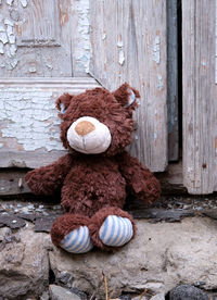 Close-up of stuffed toy on wood against wall