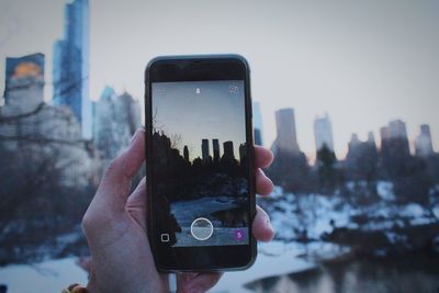 Cropped image of man photographing through smart phone