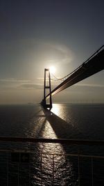 Bridge over sea against sky during sunset