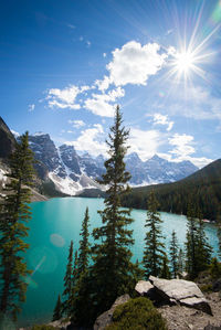 Scenic view of lake and mountains against blue sky