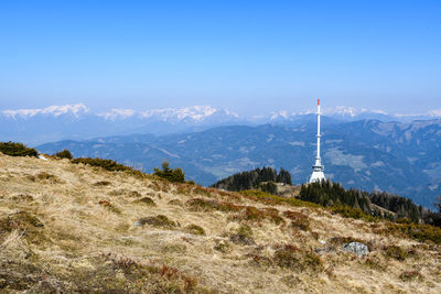 View of communications tower and mountain against sky